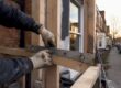Builder measuring timber frame on refurbishment site
