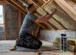 Builder fitting roof insulation in loft