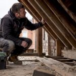Builder inspecting roof structure of Liverpool terrace