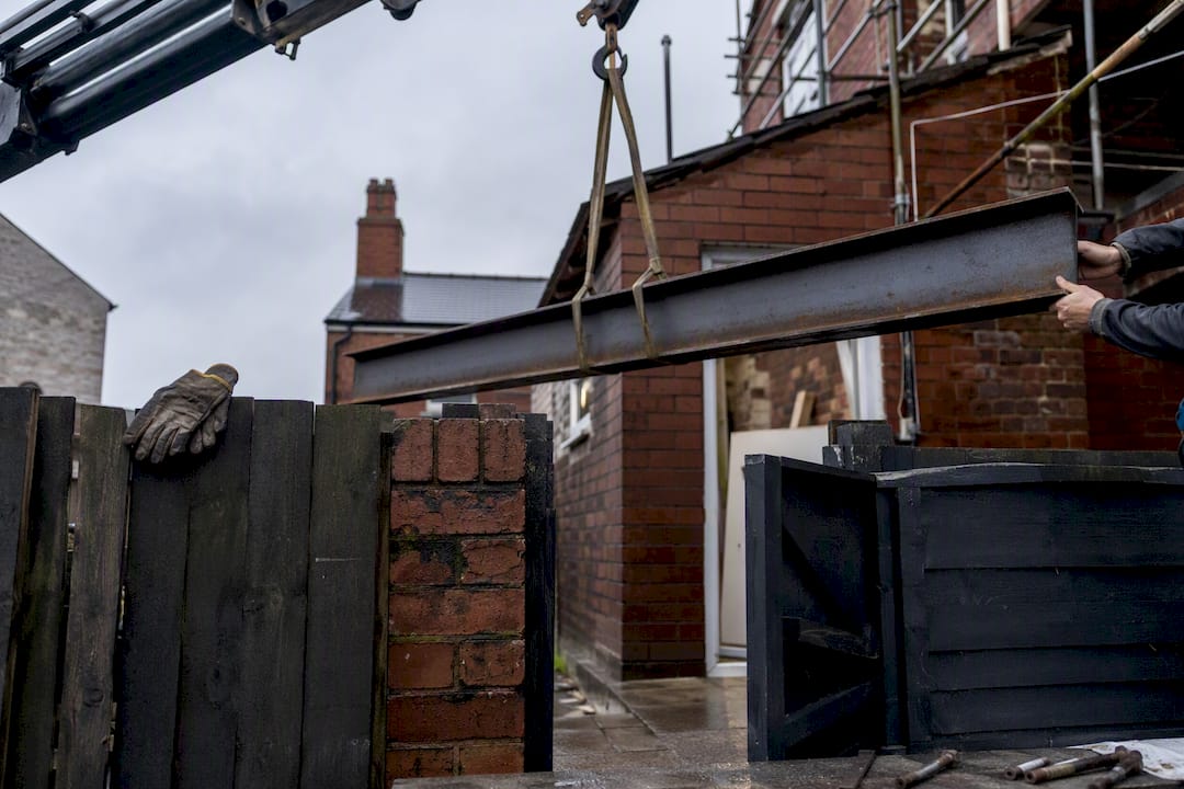 Mini-crane lifting steel RSJ beam outside Liverpool home