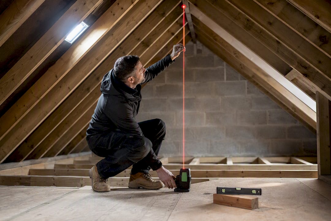 Surveyor measuring loft ridge height